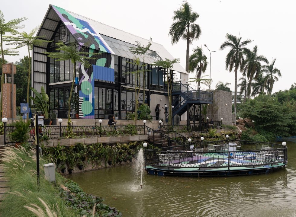 Pemandangan coffee shop konsep open space di Jakarta Selatan dengan latar belakang langit senja dan gedung tinggi.